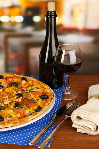 Leckere Pizza mit Wein auf Holztisch auf Zimmerhintergrund Nahaufnahme — Stockfoto
