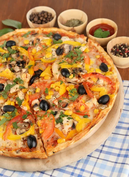 Tasty pizza with kitchen herbs on wooden table close-up — Stock Photo, Image