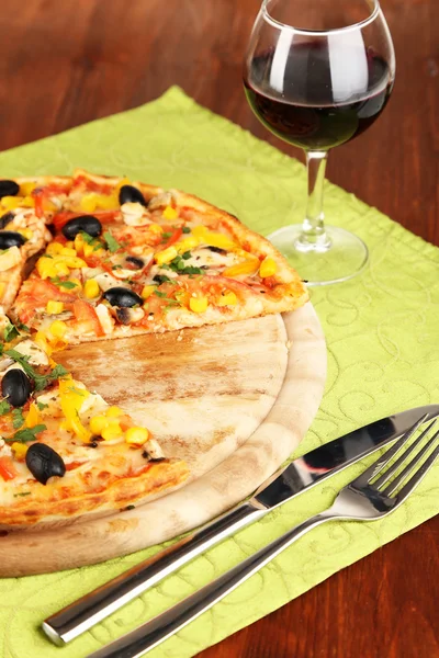 Leckere Pizza mit Wein auf Holztisch in Großaufnahme — Stockfoto