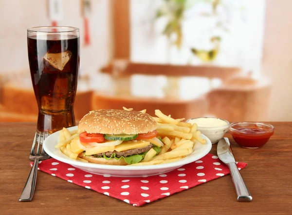 Smakelijke cheeseburger met gebakken aardappelen en koud drankje, op lichte achtergrond — Stockfoto