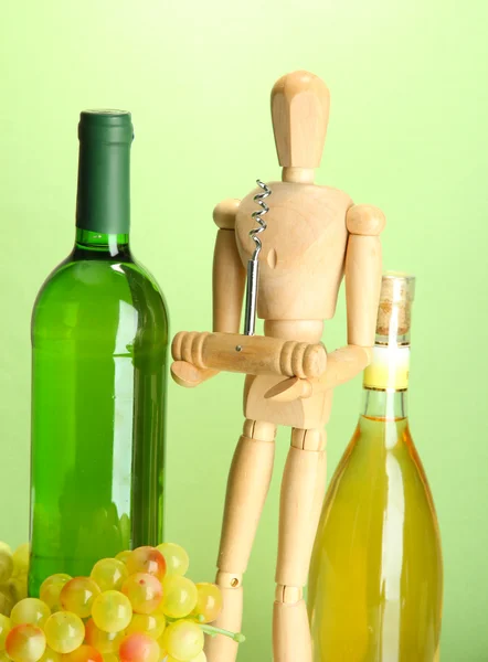 Manekýn s vývrtkou a láhev vína, na zeleném pozadí模特与开瓶器和葡萄酒瓶，绿色背景 — 图库照片