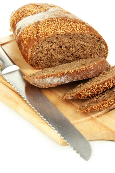 Bread with sesame seeds and knife on wooden board close up — Stock Photo, Image