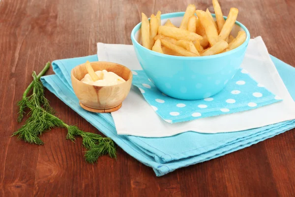 Batatas fritas em tigela na mesa de madeira close-up — Fotografia de Stock