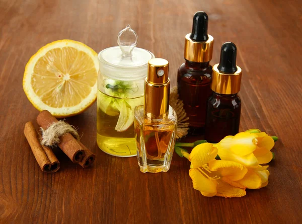 Garrafas com ingredientes para o perfume em fundo de madeira — Fotografia de Stock