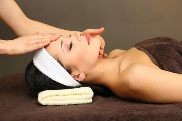 Hermosa joven en el salón de spa tomando masaje en la cabeza, sobre fondo oscuro —  Fotos de Stock