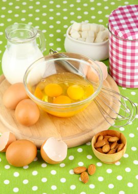 kırık yumurta kase ve yanlarında çeşitli maddeler üzerinde yeşil masa örtüsü yakın çekim