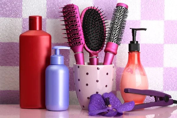 Brosses à cheveux et bouteilles cosmétiques dans la salle de bain — Photo