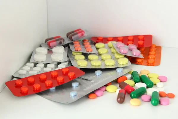Coloridas pastillas y cápsulas en el estante — Foto de Stock