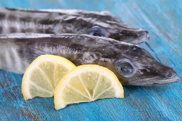 Fish with lemon on blue wooden table — Stock Photo, Image