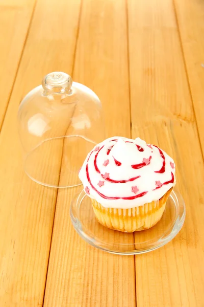 Cupcake en platillo con tapa de vidrio, sobre fondo de madera — Foto de Stock