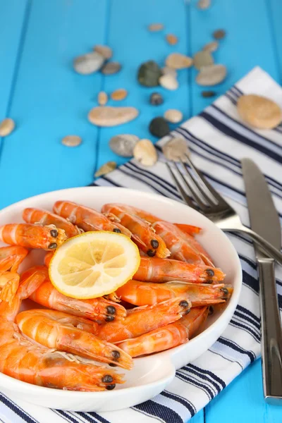 Shrimps with lemon on plate on wooden table close-up — Stock Photo, Image