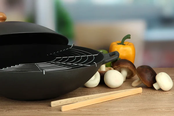 Preto wok pan e legumes na mesa da cozinha, close-up — Fotografia de Stock