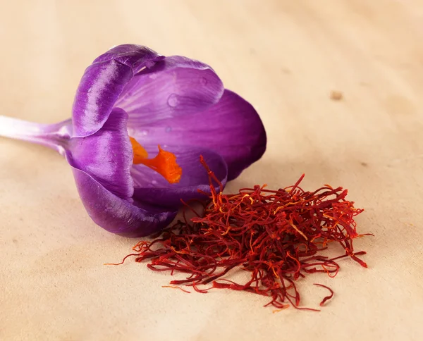 Beautiful purple crocus and saffron, on wooden background — Stock Photo, Image