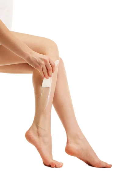 Красивые женские ноги с кремом для депиляции, изолированные на белом — стоковое фото