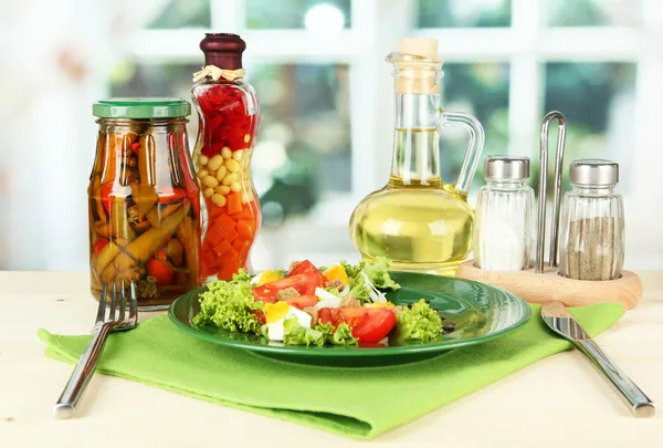 Insalata mista fresca con uova, pomodoro, foglie di insalata e altre verdure sul piatto di colore, su sfondo brillante — Foto Stock