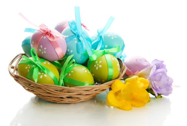 Huevos de Pascua brillantes con arcos en cesta, aislados en blanco — Foto de Stock