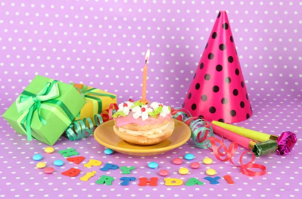 Colorful birthday cake with candle and gifts on pink background — Stock Photo, Image