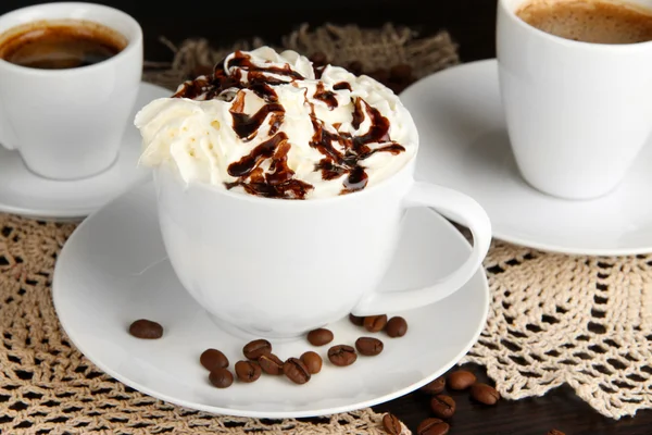 Cup of whipped cream coffee on wooden table close up — Stock Photo, Image