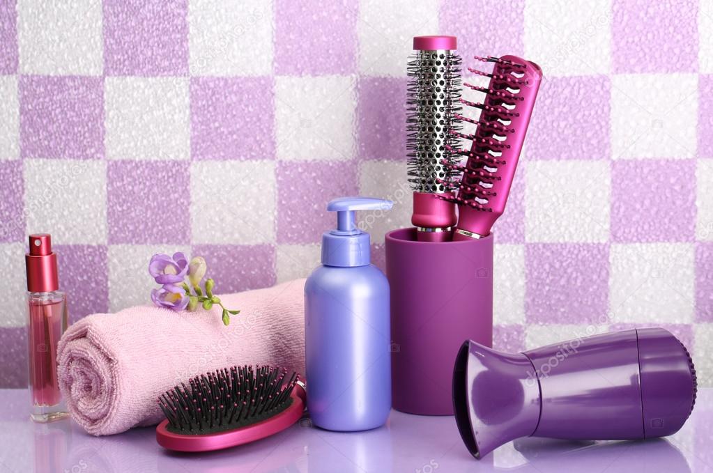 Hair brushes, hairdryer and cosmetic bottles in bathroom