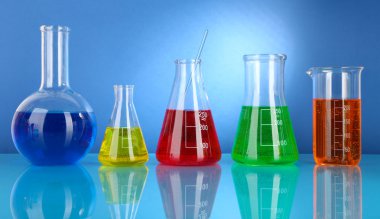 test tüpleri ile mavi arka plan üzerinde renkli sıvı