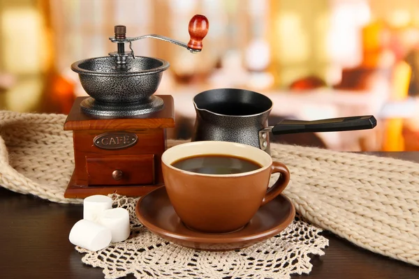 Kopp kaffe med halsduk och kaffe mal på bordet i rummet — Stockfoto