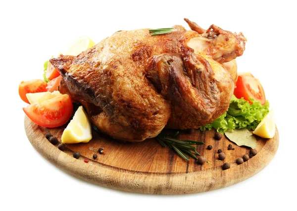 Whole roasted chicken on wooden plate with vegetables, isolated on white — Stock Photo, Image