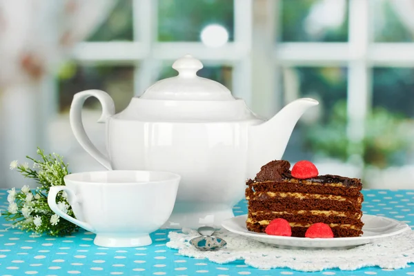 Tetera, taza de té y delicioso pastel en el fondo de la ventana —  Fotos de Stock