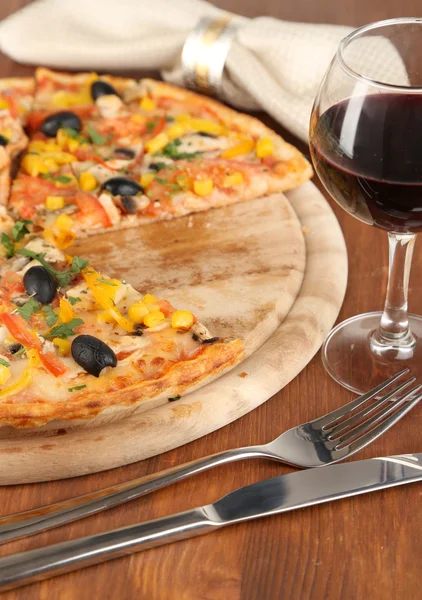 Leckere Pizza mit Wein auf Holztisch in Großaufnahme — Stockfoto