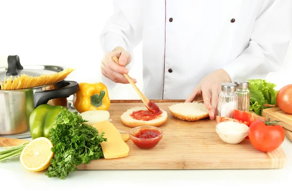 Mãos femininas preparando cheeseburger, isolado em branco — Fotografia de Stock