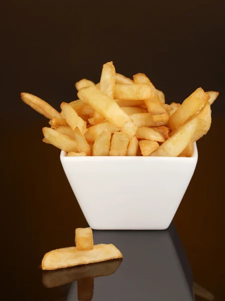 Batatas fritas em tigela isoladas em preto — Fotografia de Stock