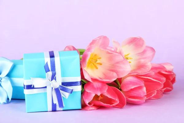 Розовые тюльпаны и подарочные коробки, на цветном фоне — стоковое фото