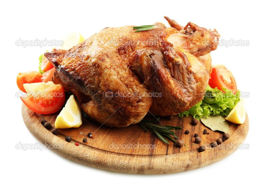 Whole roasted chicken on wooden plate with vegetables, isolated on white
