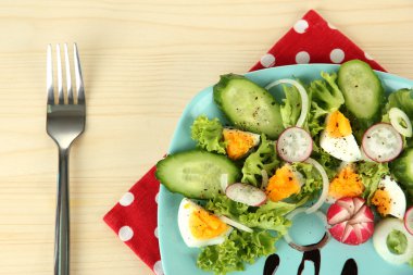 yumurta, ahşap arka plan üzerinde renkli plaka üzerinde diğer sebze ve salata yaprakları taze karışık salata