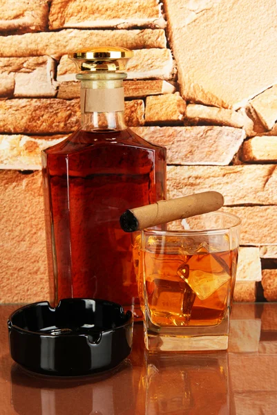 Şişe ve bardak viski ve puro tuğla üzerinde arka plan duvar — Stok fotoğraf