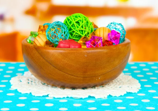 Сушеные апельсины, плетеные шарики и другие украшения дома в деревянной чаше, на ярком фоне — стоковое фото