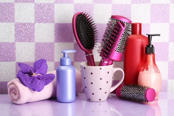 Kartáče na vlasy a kosmetické lahví v koupelně — Stock fotografie