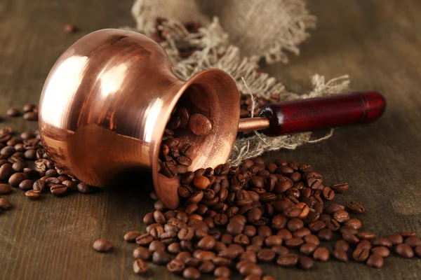 Coffee pot with coffee beans on wooden background — Stock Photo, Image