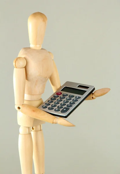 Wooden mannequin with calculator on grey background — Stock Photo, Image