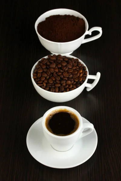 Різні види кави в трьох чашках на дерев'яному столі — стокове фото