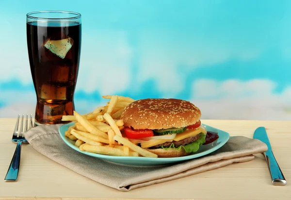 Sabrosa hamburguesa con patatas fritas y bebida fría, sobre fondo brillante — Foto de Stock