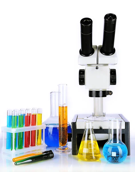 Test tubes with colorful liquids and microscope isolated on white — Stock Photo, Image