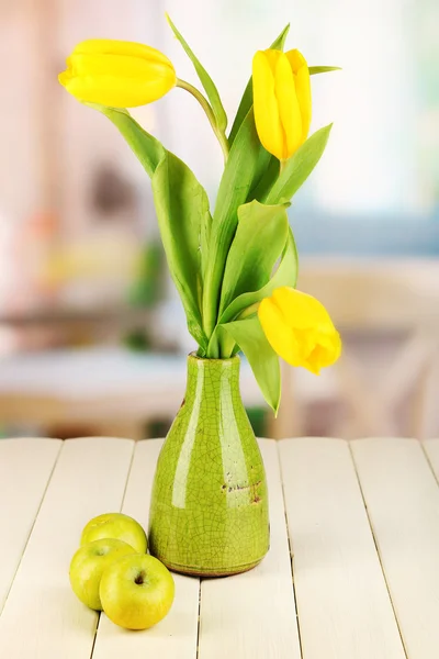 Gelbe Tulpen in Vase auf Holztisch auf Zimmerhintergrund — Stockfoto