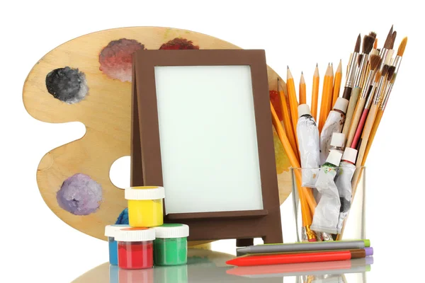 Photo frame as easel with artist's tools isolated on white — Stock Photo, Image