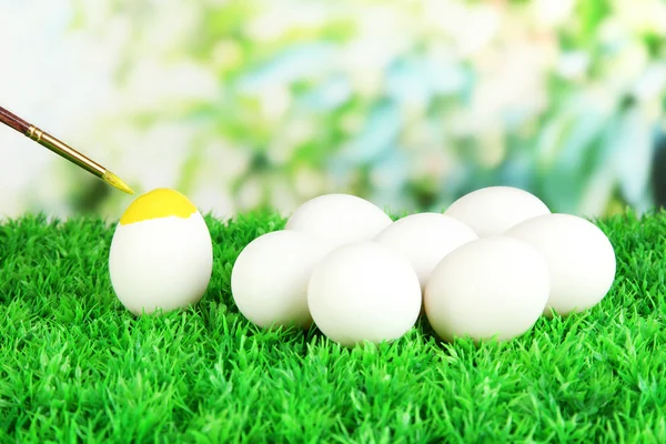 Ovos de Páscoa na grama no fundo brilhante — Fotografia de Stock