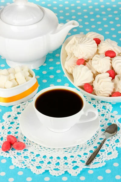 Schönes weißes Abendessen mit Luftmeringues auf blauer Tischdecke in Großaufnahme — Stockfoto