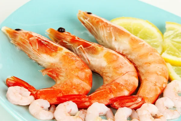 Shrimps with lemon on plate isolated on white — Stock Photo, Image