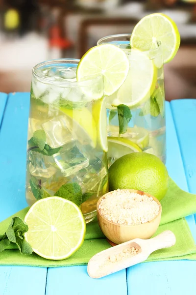 Glas cocktail med lime och mynta på blå träbord på ljus bakgrund — Stockfoto