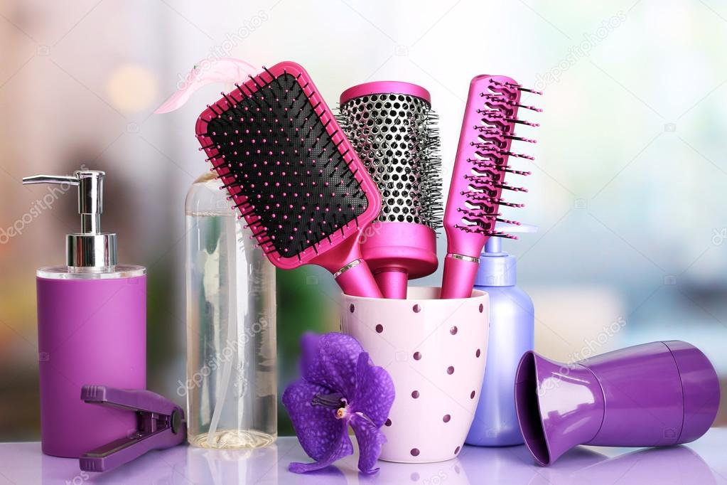 Hair brushes, hairdryer, straighteners and cosmetic bottles in beauty salon