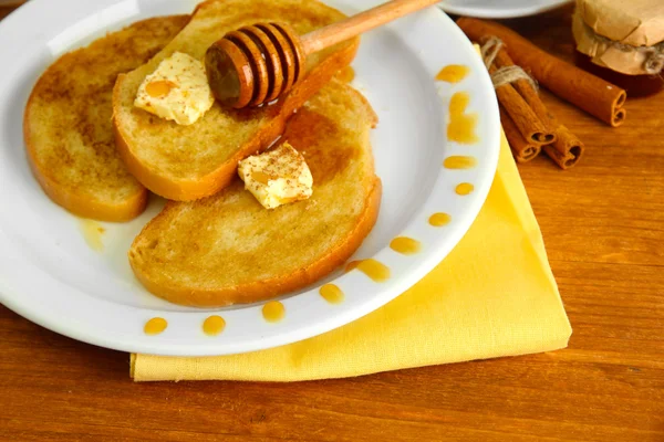 Тост из белого хлеба с медом и чашкой кофе на деревянном столе — стоковое фото