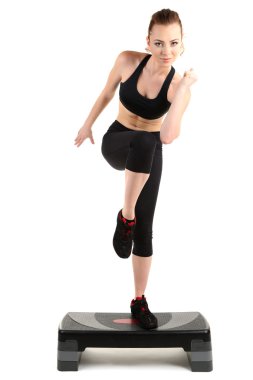 Young woman doing fitness exercises on stepper isolated on white